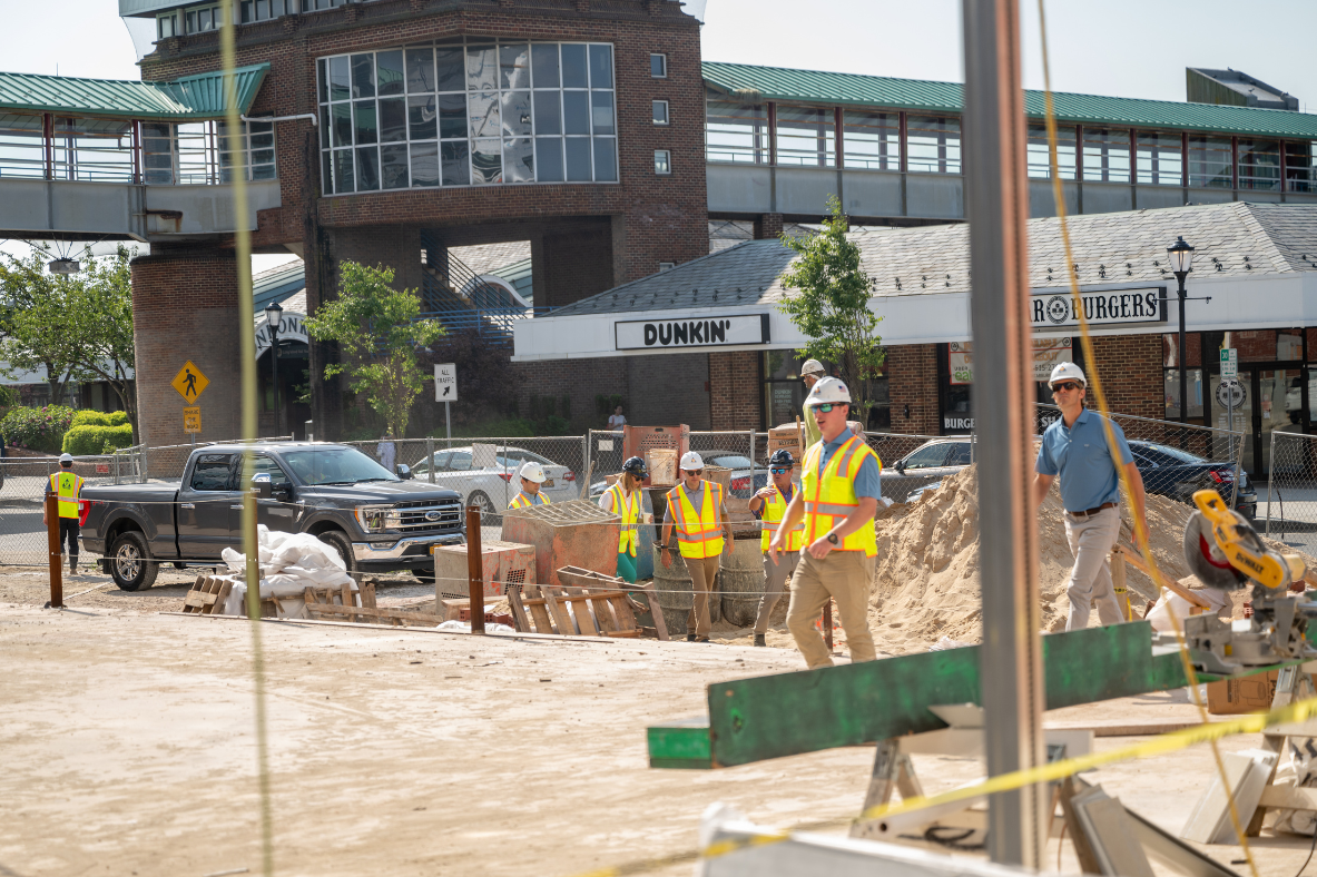 Visitors wearing hardhats and safety vests walking the construction site at Station Yards